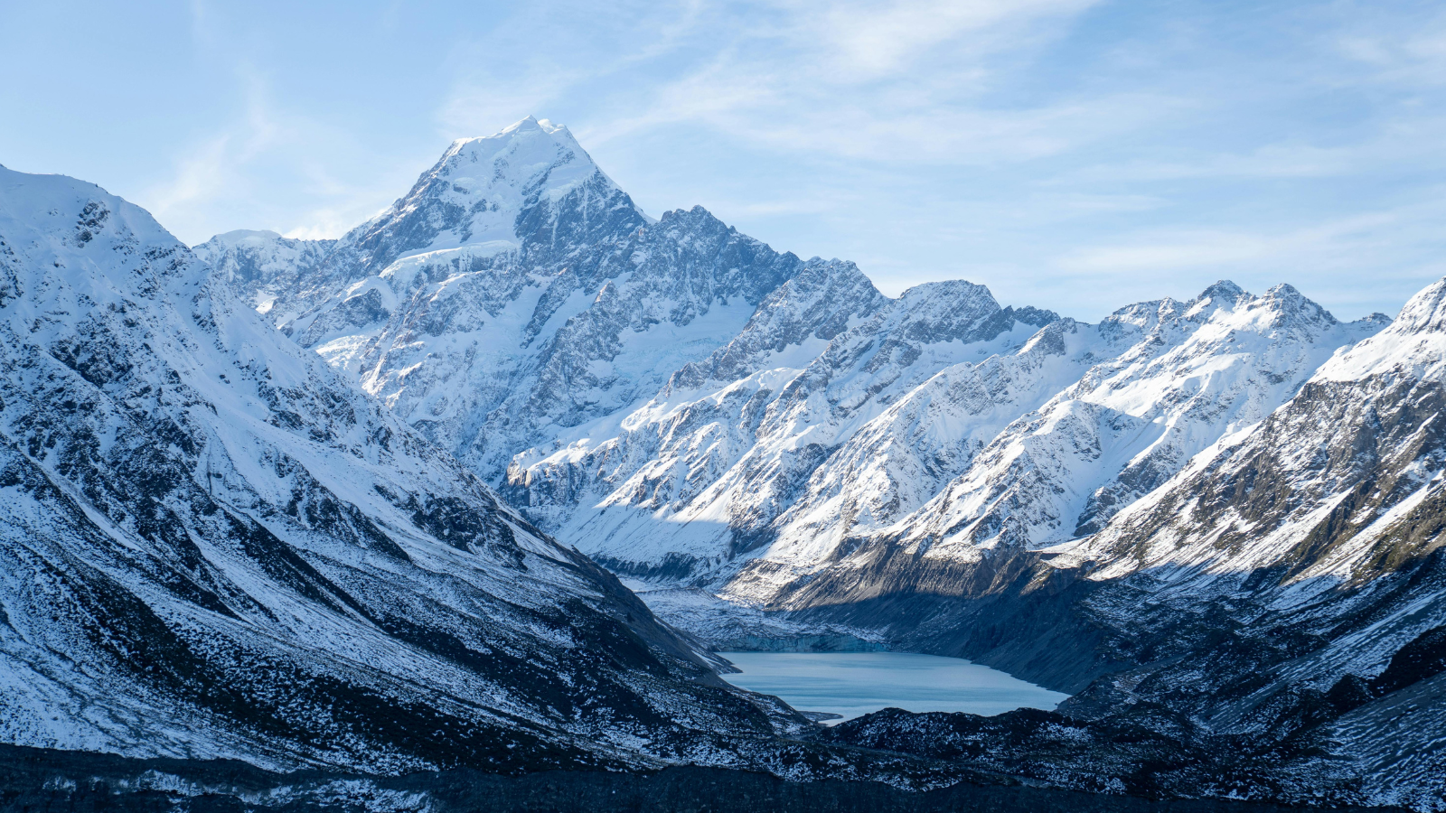 Aoraki / Mount Cook rising above a glacial lake in the Southern Alps of Aotearoa New Zealand, surrounded by snow-covered mountain ranges